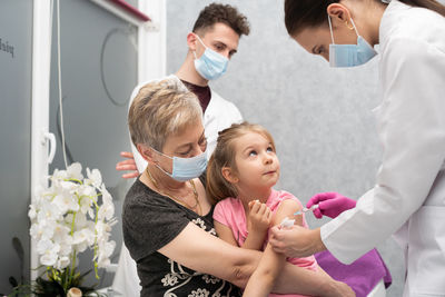 Portrait of siblings playing with daughter