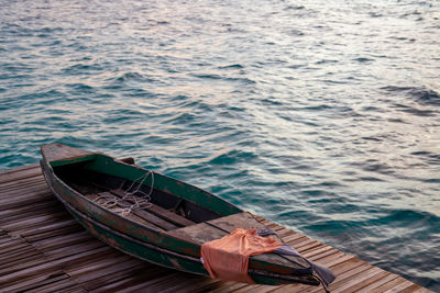 Old wooden boat sitting on the pier overlooking the beautiful semporna turquoise sea.