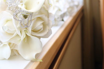 Close-up of diamond jewelry on white wedding bouquet