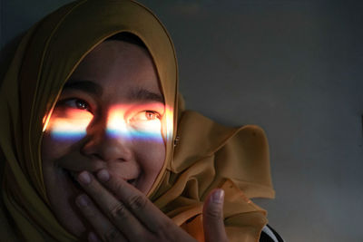 Close-up of multi colored light on woman eye at home