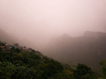 Scenic view of mountains against sky at foggy weather