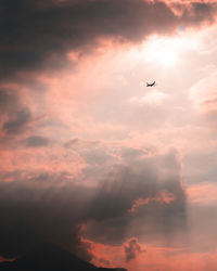 Low angle view of silhouette airplane flying in sky