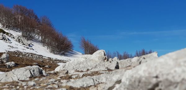 Scenic view of snowcapped mountains against blue sky