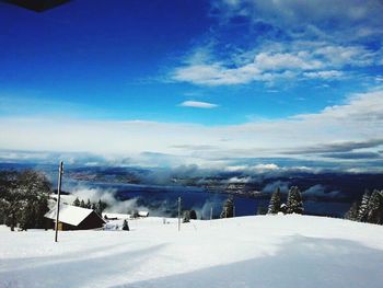 Scenic view of snow covered mountains against cloudy sky