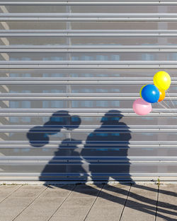 Multi colored balloons on wall in city