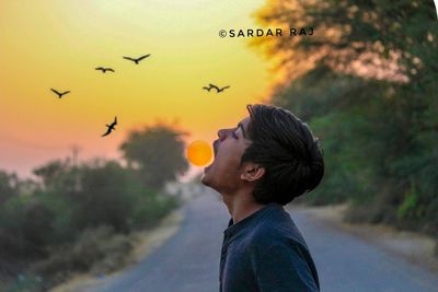 Portrait of young man standing against sky during sunset