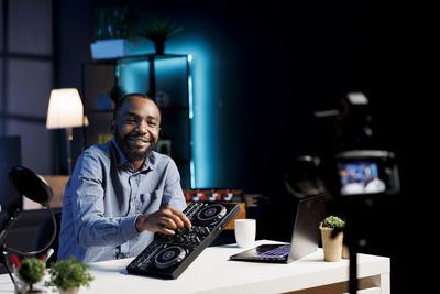 Portrait of young man using mobile phone in office