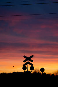 Silhouette pole on field against sky during sunset