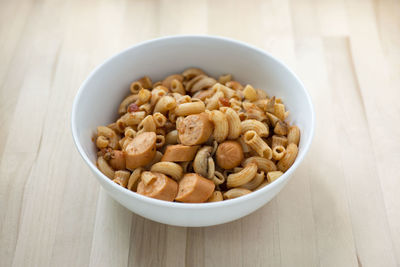 Close-up of pasta and mushrooms in bowl on wooden table