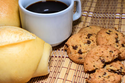 Close-up of cookies with coffee on straw mat
