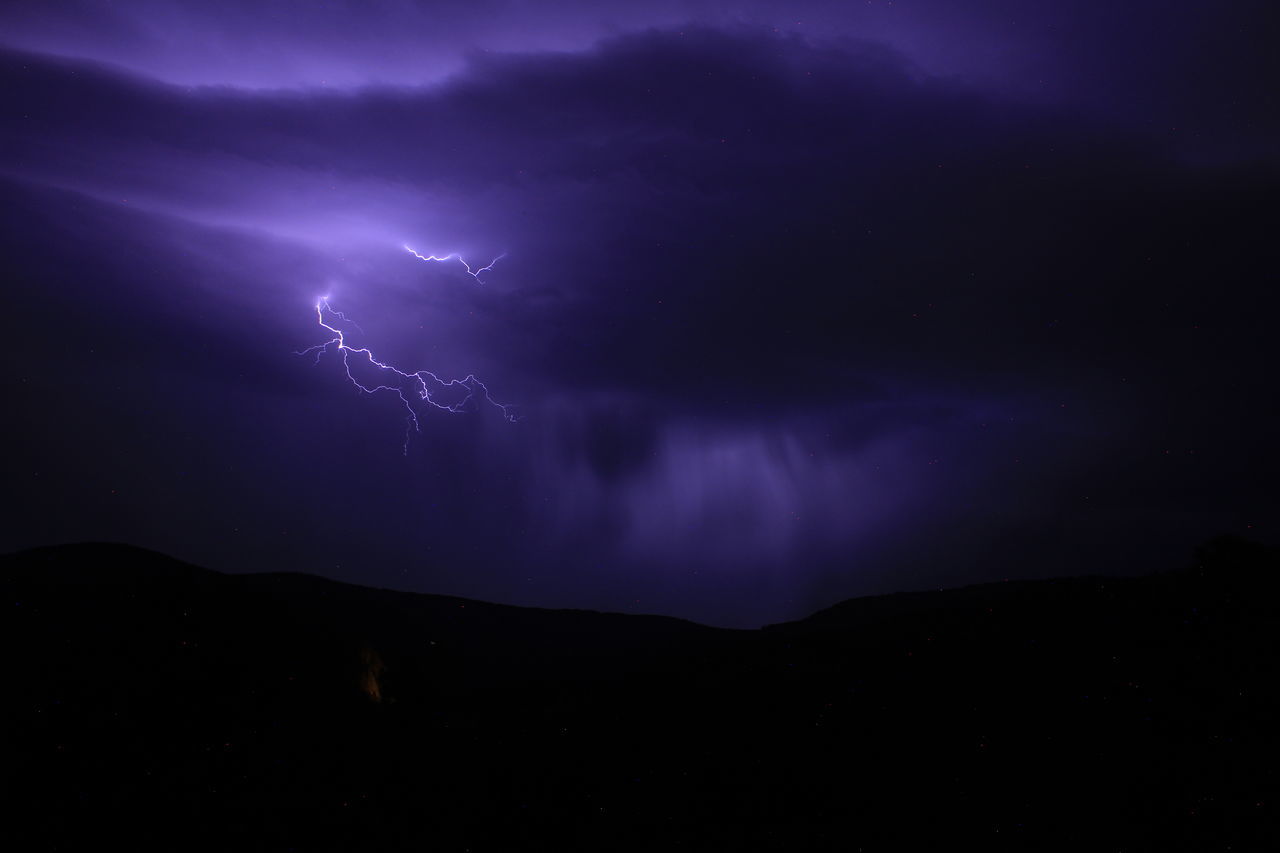 lightning, power in nature, storm, thunderstorm, cloud, beauty in nature, sky, night, warning sign, thunder, dramatic sky, environment, storm cloud, sign, forked lightning, communication, nature, mountain, scenics - nature, no people, electricity, purple, awe, dark, outdoors, atmospheric mood, silhouette, light - natural phenomenon, landscape, overcast