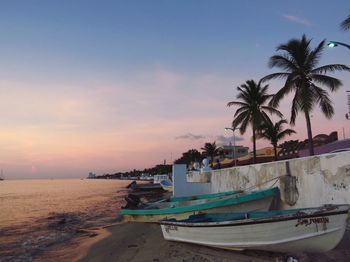 Boats in sea at sunset