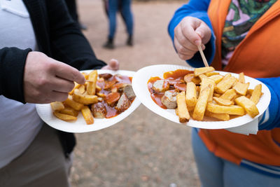 Midsection of people holding food