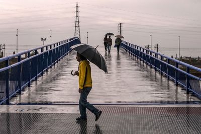 Full length rear view of woman walking on footpath