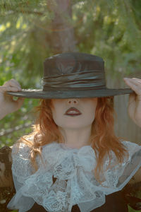 Young woman wearing hat standing outdoors