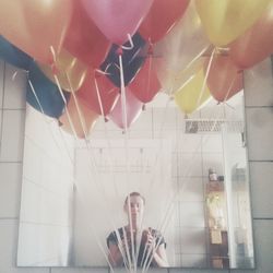 Selfie of woman standing in front of mirror with balloons