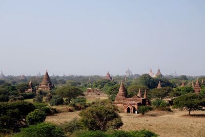 View of buddhist monuments on landscape against sky