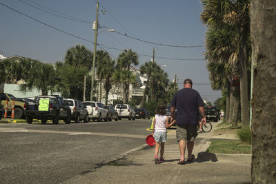 Rear view of man walking on road