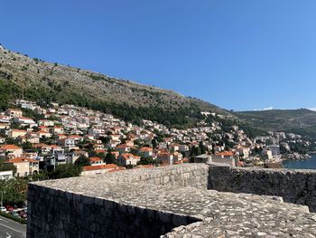 Town by mountain against clear blue sky