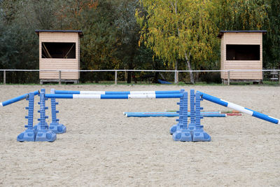 Empty benches against blue sky and trees in park