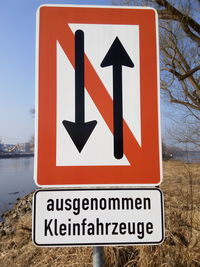 Close-up of road sign against sky