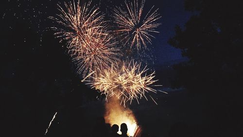 Low angle view of firework display at night