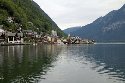 Scenic view of lake by buildings against sky