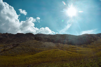 Scenic view of landscape against bright sun