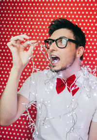 Close-up of man wearing eyeglasses against gray background