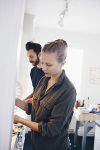 Tilt shot of couple working in kitchen at home