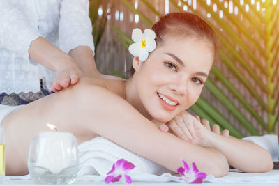 Portrait of smiling woman lying down on plant