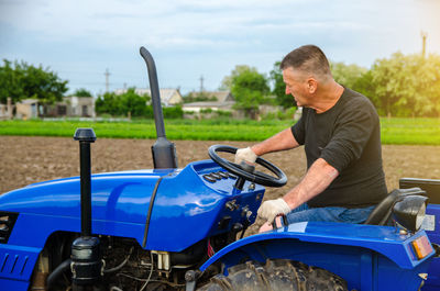 A farmer is driving a tractor. agro industry, agribusiness. farming, agriculture. 