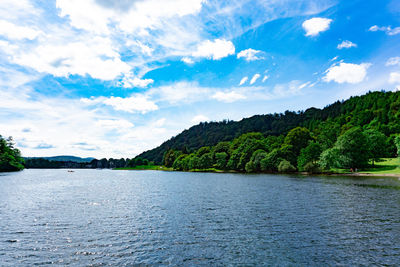 Scenic view of river by trees against sky