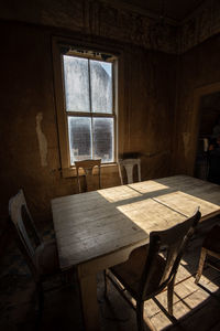 Sunlight window streams onto old wooden table in ghost town