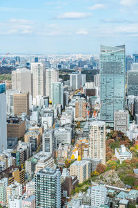 Aerial view of buildings in city against sky