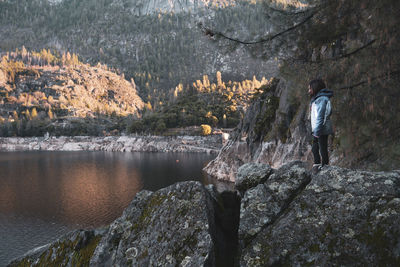 Girl standing on rock against lake