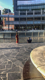 Rear view of people on street against buildings in city