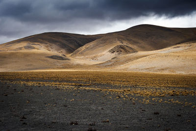 Road by mountains against sky