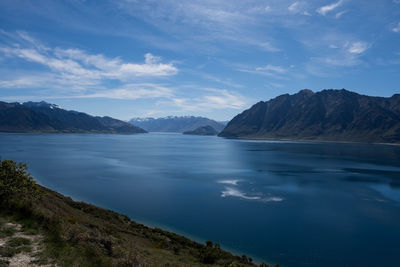 Scenic view of sea and mountains against sky