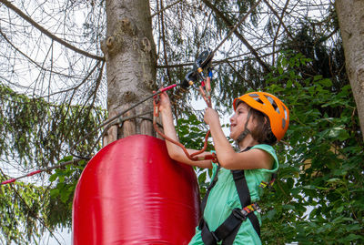 Adventure climbing high wire park - people on course in mountain helmet and safety equipment