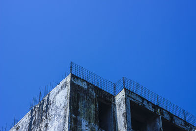 Low angle view of old building against clear blue sky