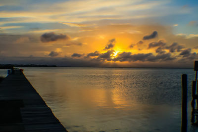 Pier on sea at sunset