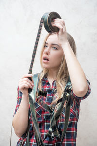 Portrait of young woman holding camera