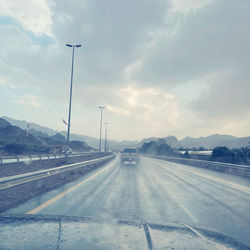 Cars on road against sky during winter