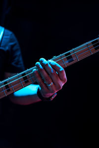 Midsection of man playing guitar