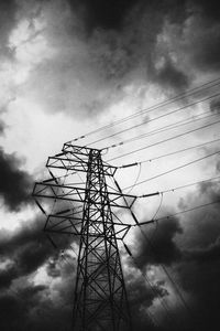 Low angle view of silhouette electricity pylon against sky