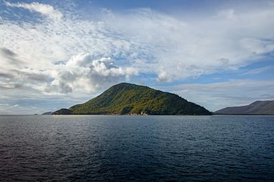 Perfectly placed green island framed by the sea and sky