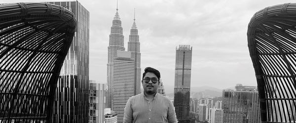 Portrait of man against modern buildings in city