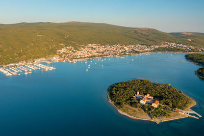 Aerial view of kosljun monastery with punat town in the background, krk island, croatia