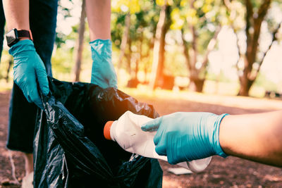 Volunteer holding plastic garbage clean to dispose of waste properly.